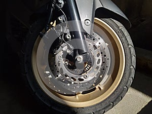 The front tire of a Yamaha Nmax motorbike in the motorbike parking lot