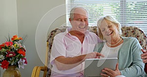 Front view of active Caucasian senior couple using digital tablet at nursing home 4k