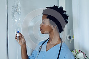 Female doctor adjusting iv drip in the ward at hospital photo