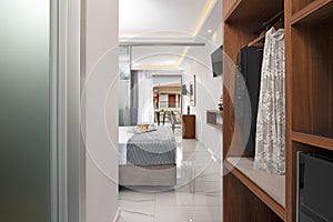 Front view of apartment entrance hallway with wooden wardrobe cabinet. Modern bedroom hotel interior room and old city street view