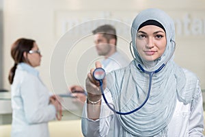 Front view of an arab doctor woman showing stethoscope.