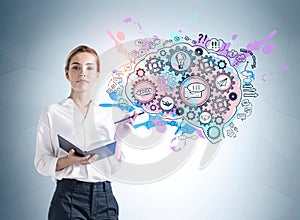 Front view of attractive young woman in formal wear holding a planner and standing near grey wall with creative colorful idea