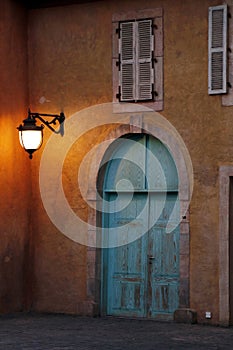 front view of and Authentic old house with wooden door and glass window, hanging light on the wall