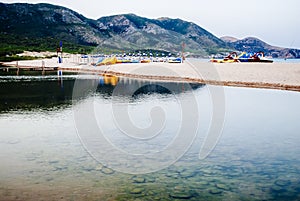 Front view of bathhouse with mountains in the background in the early summer morning.