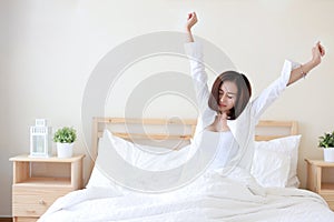 Front view beautiful and healthy young asian woman wake up in the morning, she stretching after wake up in the morning on white
