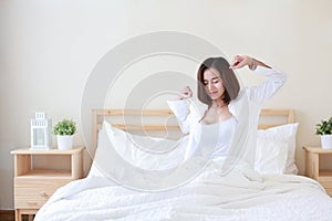 Front view beautiful and healthy young asian woman wake up in the morning, she stretching after wake up in the morning on white