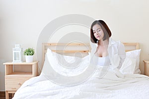 Front view beautiful and healthy young asian woman wake up in the morning, she stretching after wake up in the morning on white be