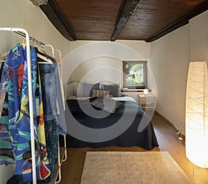 Front view bedroom with double bed, bedside table with a lamp above and a wardrobe on the left