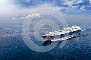 Front view of a big LNG tanker ship travelling over the calm, blue ocean