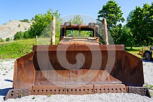 Front view of big rusty bucket of old huge heavy crawler bulldozer, abandoned vintage dozer