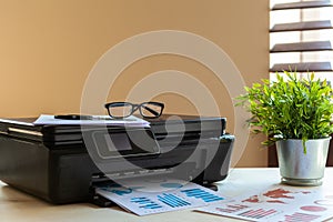 Front view of a black printer machine on a table