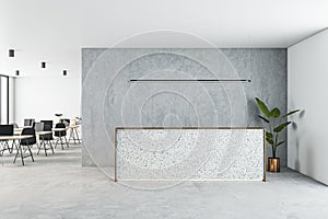 Front view on blank reception desk with space for product presentation on light concrete floor, grey wall and coworking office