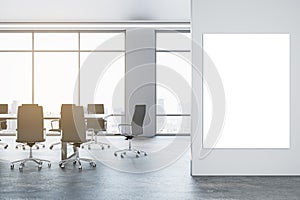 Front view of blank poster on light wall and empty modern conference room, with window, office desk and chairs on a