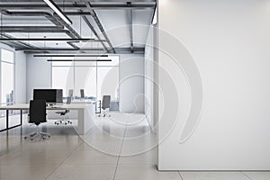 Front view on blank white wall with place for advertising poster in spacious office with monochrome interior design, light floor,