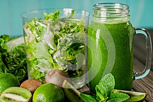 Front view of blended green smoothie with fruit and vegetables on wood rustic table. Vitamin food