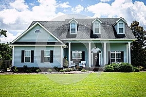 Front View of blue house with siding in the suburbs