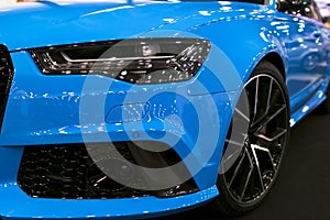 Front view of blue modern luxury sport car. Car exterior details. Headlight of a modern sport car. The front lights of the car.
