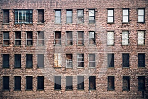 Front view of a boarded-up abandoned brick skyscraper building windows from the street in New York City photo
