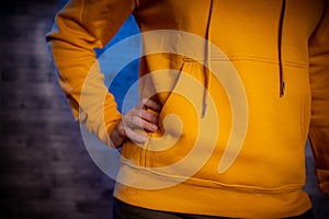 Front view on body part of young female in sweatshirt. Close up of figure of unrecognizable woman with propping her hand