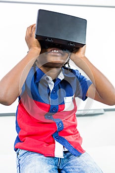 Front view of boy using virtual reality headset in classroom