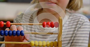 Front view of Caucasian schoolgirl learning mathematics with abacus in the classroom 4k