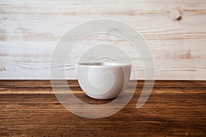 Front view of ceramic bowl on rustic table wooden background with Copy Space for Text