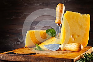 Front view on cheese lying on old burned cutting board.