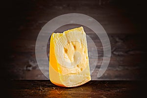 front view on cheese lying on old burned cutting board.