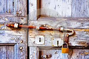Front view of a closed old wooden door with rusty metal bolt - safety concept image