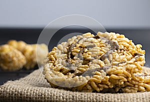 Front view closeup photo of a Thai rice cracker with sugar syrup on top put on sackcloth black background