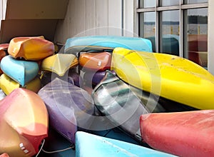 Front view of colorful canoes stacked