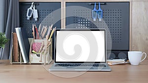 Front view computer laptop with white screen on wooden table in home office.