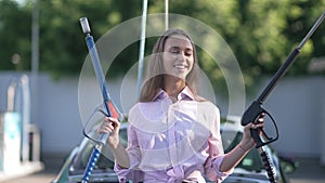 Front view confident successful happy woman posing with car wash equipment outdoors on sunny day. Beautiful Caucasian