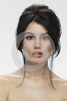 Front view of a cute brunette with bare shoulders and eye shadow makeup model,  wghite background.