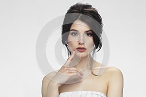 Front view of a cute brunette with bare shoulders with makeup, isolated white background.