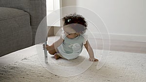Front view of cute focused infant crawling on carpet