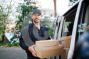 Front view of delivery man courier delivering parcel box in town.