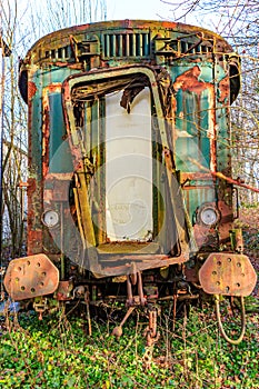 Front view of dilapidated, rusty, damaged and abandoned train carriage