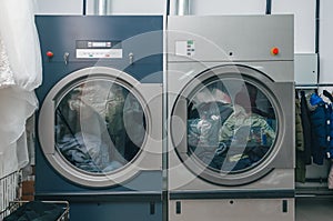 Front view of dry cleaning dryer. The dry cleaners have two dryers loaded with clothes