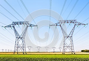 Front view of an electricity pylon in the countryside under a clear blue sky