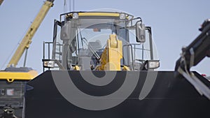 Front view of empty loader outdoors. Cabin of heavy industrial equipment. Hydraulic mover, business, industry.