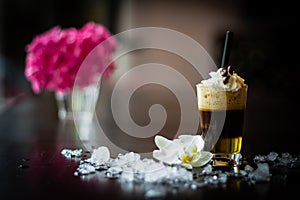 Front-view espresso macchiato with milk froth, cream and straw