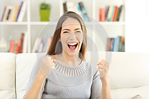 Front view of an excited woman looking at camera at home