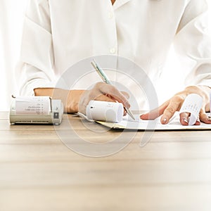 Front view of female bank employee writing something on receipts photo