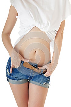 Front view of female body and legs in blue jeans shorts.