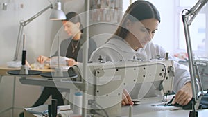 Front View Of Female Fashion Designer Working With Sewing Machine In Workshop