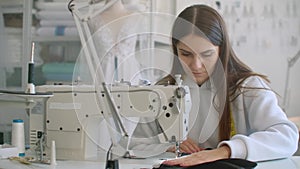 Front View Of Female Fashion Designer Working With Sewing Machine In Workshop