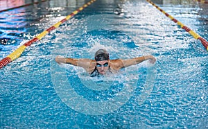 Front view of a female swimmer swimming butterfly style