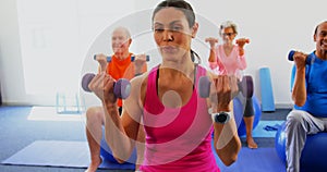 Front view of female trainer training senior people in exercise at fitness studio 4k