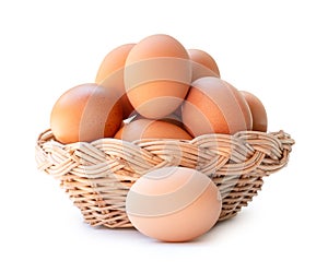 Front view of fresh brown chicken eggs in stack in wicker basket isolated on white background with clipping path